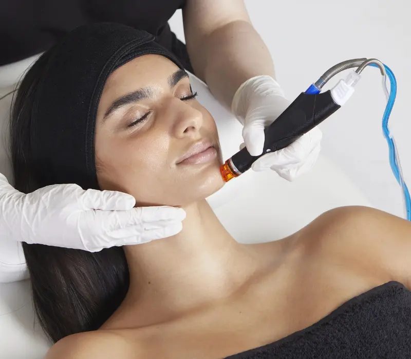 Eine Frau erhält eine erfrischende HydraFacial-Gesichtsbehandlung für strahlende Haut.